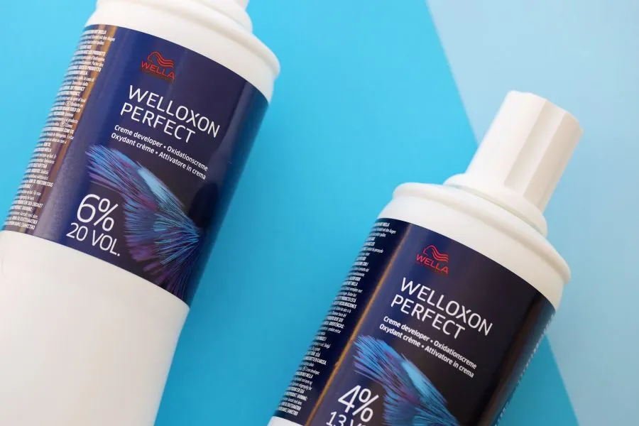 Two Wella hair care products on a blue background.